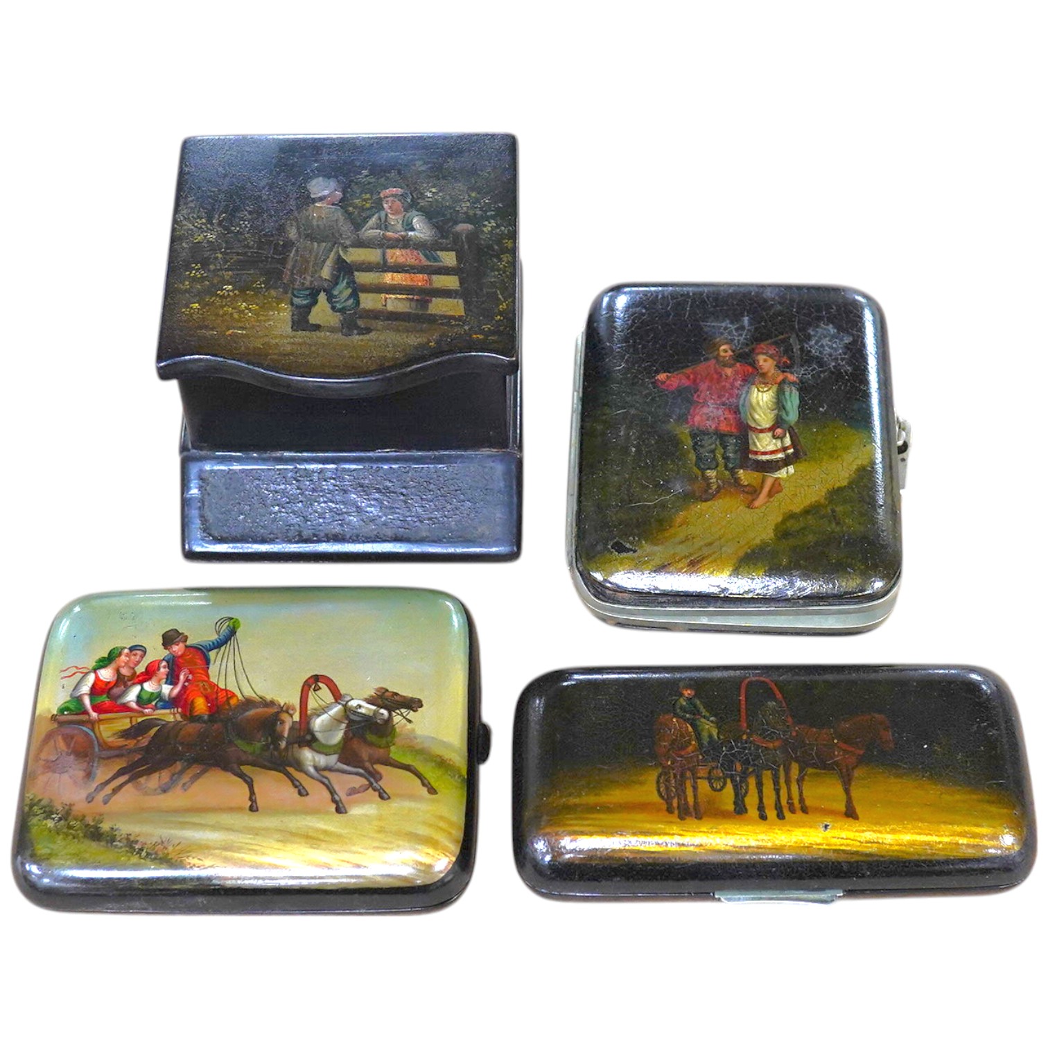 Three Russian lacquer cigarette cases, late 19th/early 20th century, one decorated with a troika scene and a match strike, 11cm wide. Condition - good